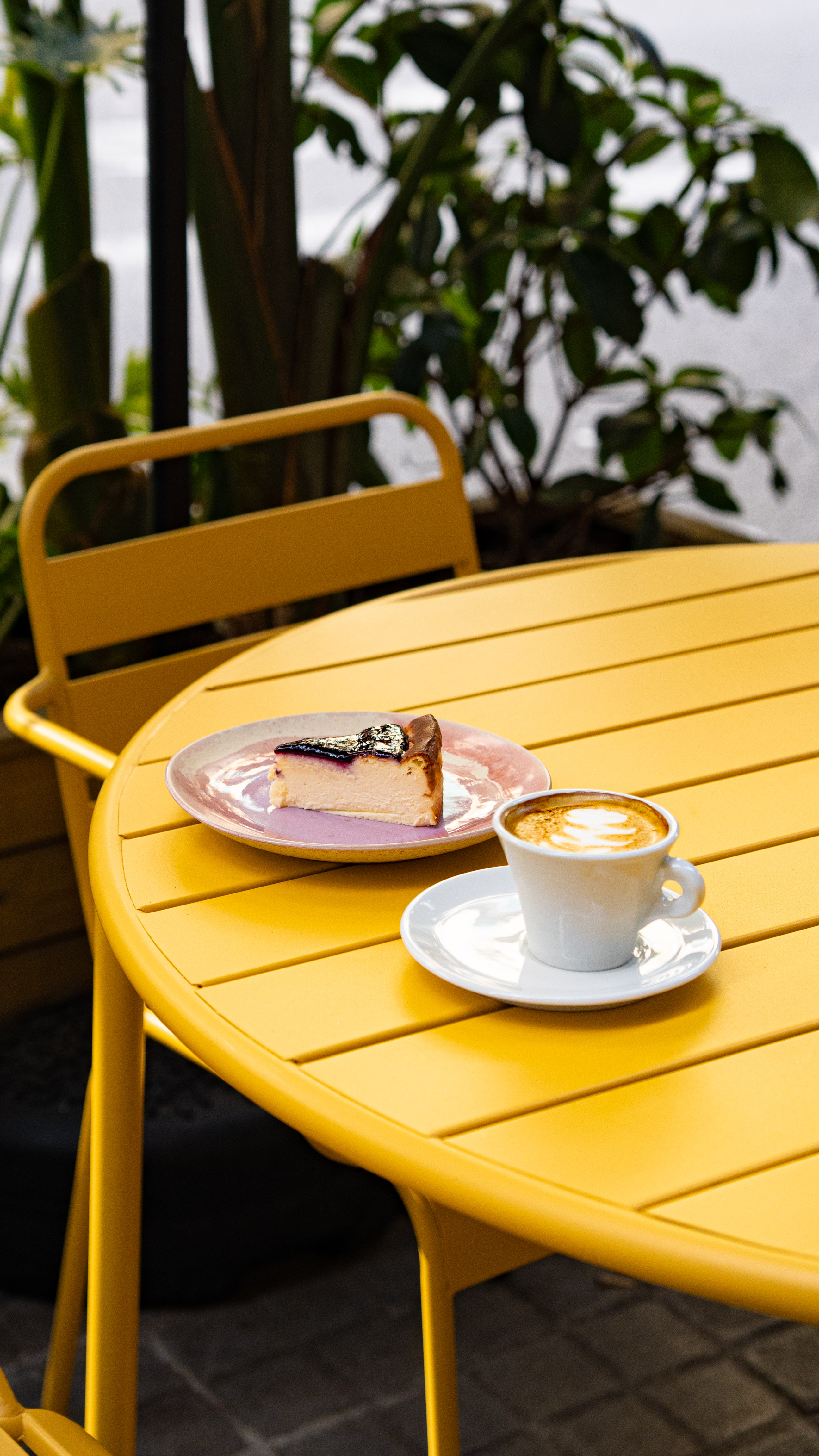 Tarta de queso y café con leche en mesa de Afecte